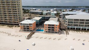 A beachfront hotel with multiple buildings, a swimming pool, and a sandy beach. - Top Floor Beachside Condo in Gulf Shores Sleeps 6 (Gulf Shores)
