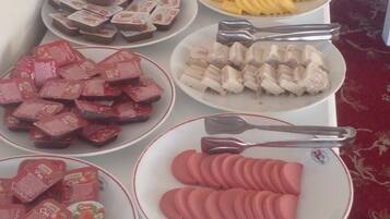 Una mesa de buffet con diversos alimentos, incluyendo frutas, verduras y bocadillos empaquetados.