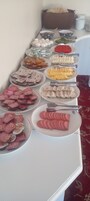 Una mesa de buffet con diversos alimentos, incluyendo frutas, verduras y bocadillos empaquetados.