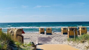 Une plage avec des chaises de plage portant les numéros RA 71, RA 72, RA 73, RA 20 et RA 22.
