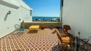 A balcony with a patterned floor, a yellow table, and a glass table with chairs. - Eagle's Nest Boutique Hotel (Istanbul)