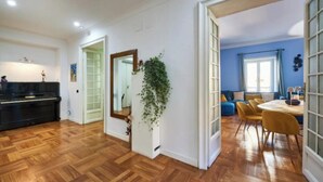 A spacious living area with a piano, a dining table with chairs, and a blue sofa. - A Blend of Historical Elegance and Modern Comfort (Roma)