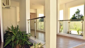 A spacious balcony with glass railings, a tiled floor, and potted plants. - Cozy studio in peaceful Diani located in a leafy and serene neighborhood (Diani)