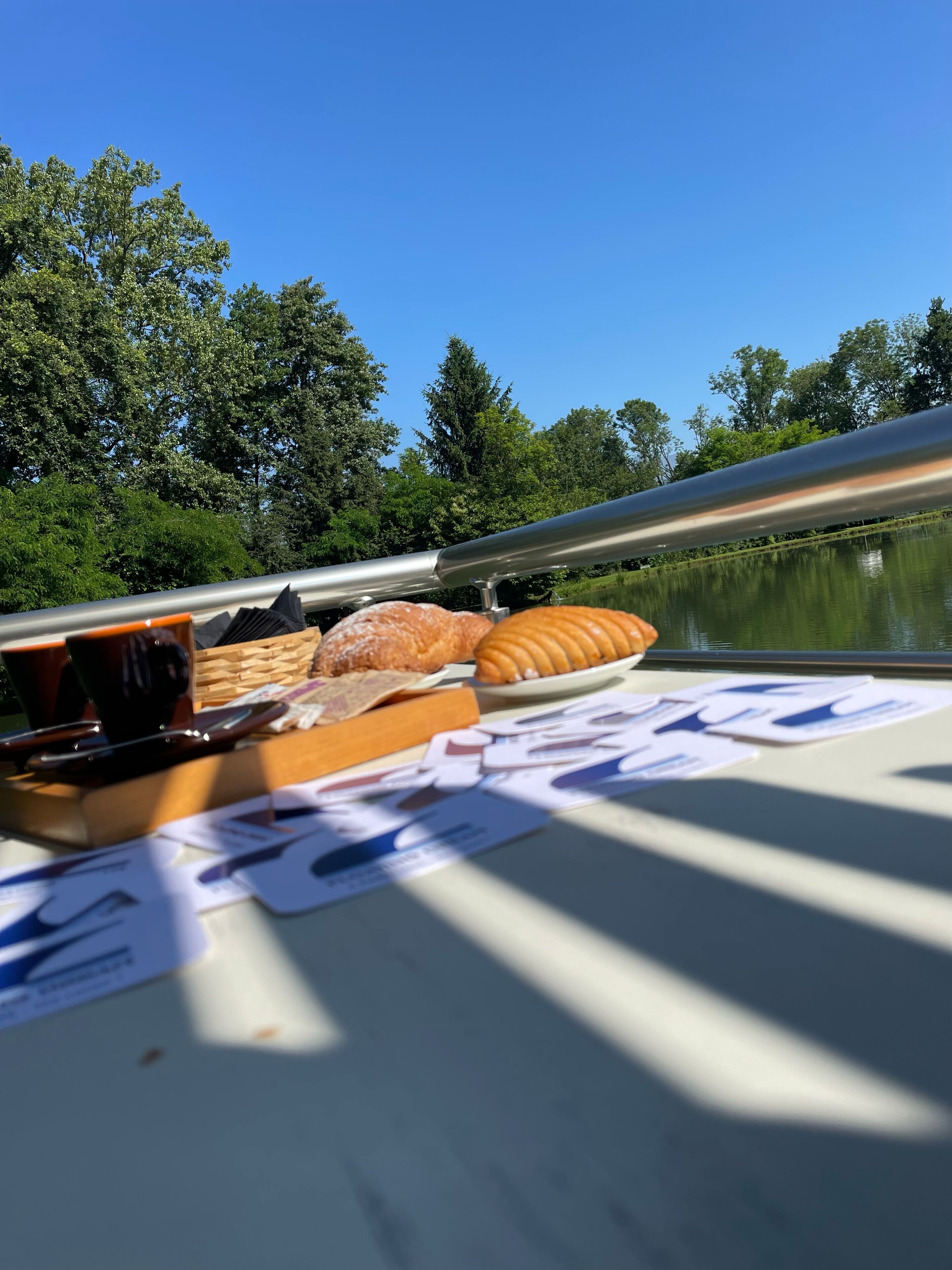 Une table dressée avec des plats et une vue sur un lac et des arbres.