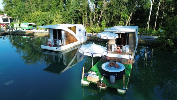 A houseboat with a deck, outdoor seating, and a hot tub. - FLOATING DREAM (Fiano)