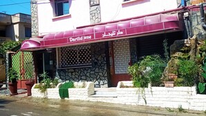 A building with a maroon awning and a sign that reads "Dartlid jene". - Tlidjene ain taya (Algiers)