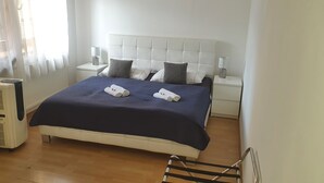 A hotel room with a large bed, two bedside tables with lamps, a radiator, and a chair. - Radio Hotel Bratislava (Bratislava)