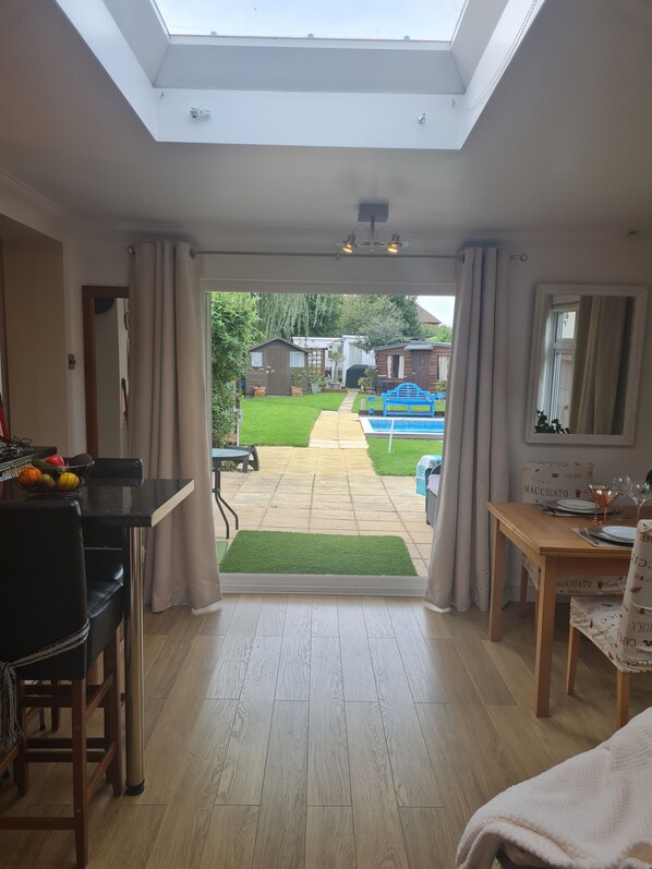 Enjoy a meal for two in the dining area, with a view of the backyard pool and garden.