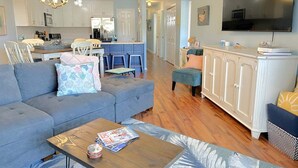 Ein modernes Wohnzimmer mit einer Couch, einem Couchtisch und einem Fernseher.
