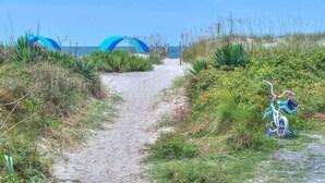 A beach path with a bicycle and a blue archway leading to the sea. - Slow n Steady: Swim Spa, Elevator, Beach Walk (Oak Island)