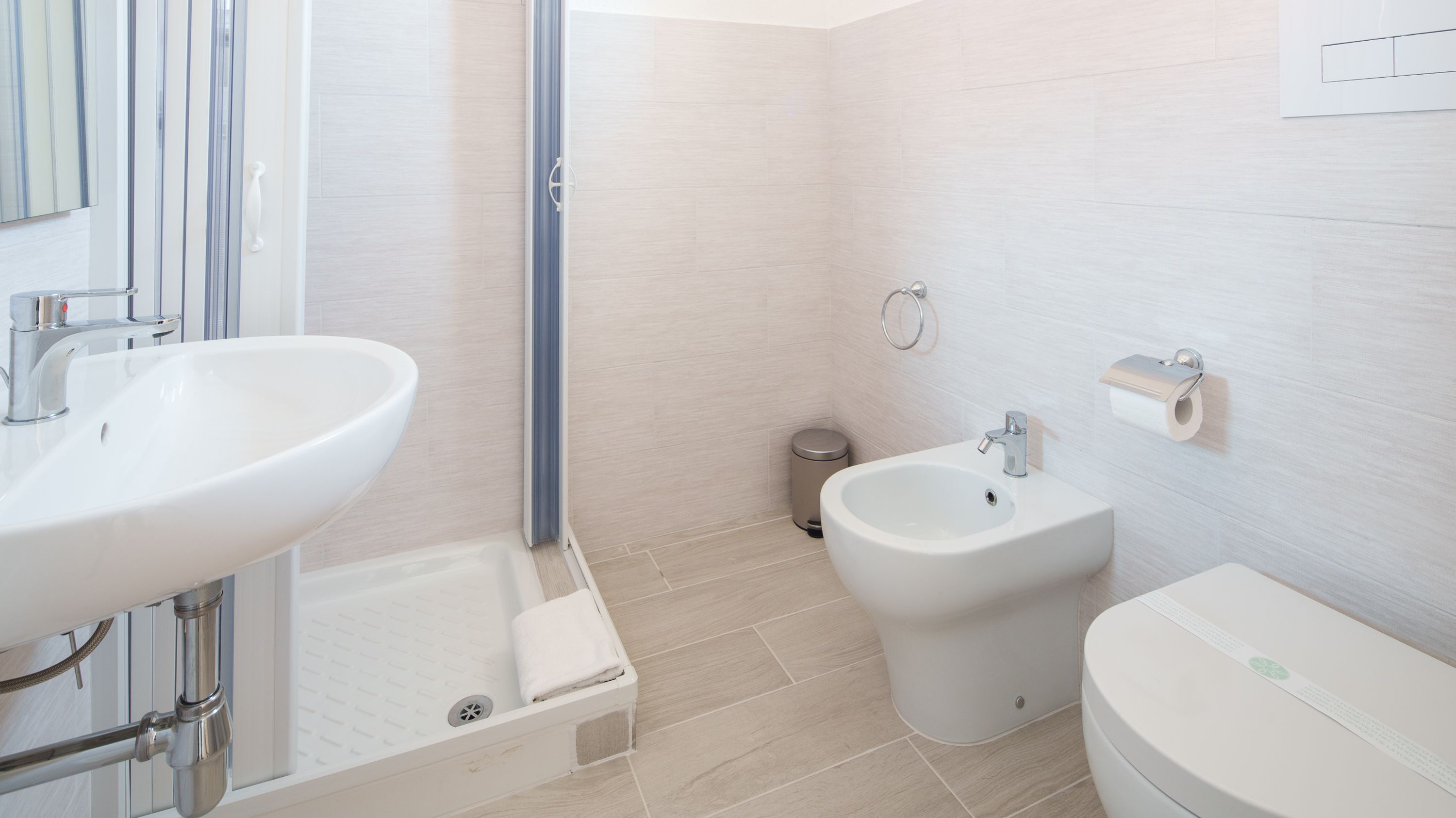 A modern bathroom with a bathtub, a bidet, a toilet, and a sink.