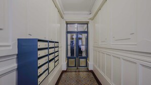A hallway with a patterned carpet, a blue filing cabinet, and a double door with glass panels.