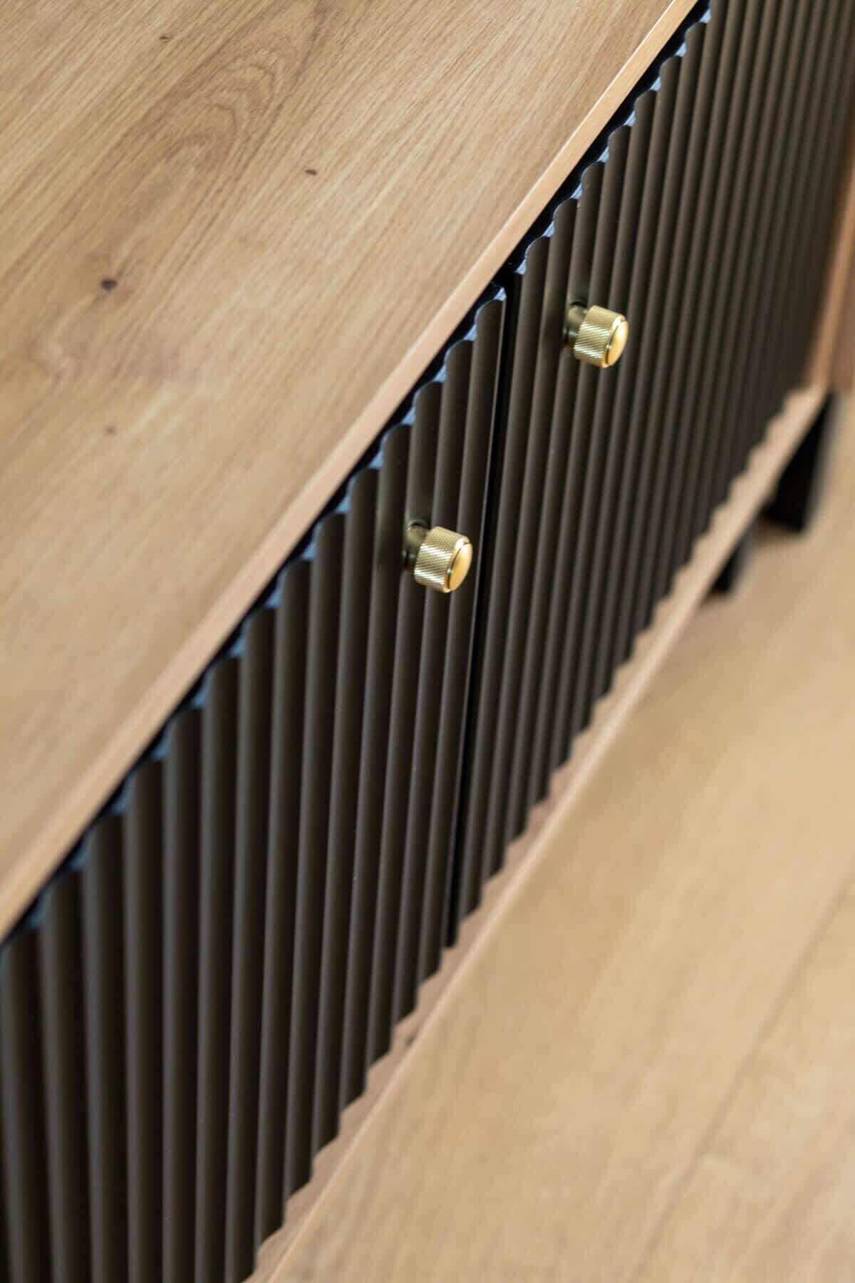 A wooden panel with a vertical vent and two brass knobs.