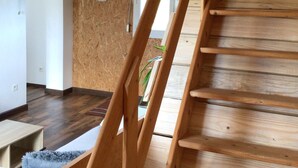 A wooden staircase leading to a room with a wooden floor and a white door.