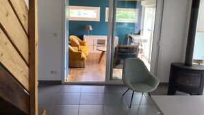 A modern living room with a sliding glass door leading to a dining area.