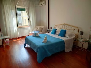 A neatly arranged bedroom with a bed, bedside tables, and a window with curtains. - Tra Pirandello e Leopardi B&B (Naples)