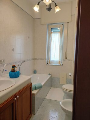 A bathroom with a bathtub, toilet, and sink. - Tra Pirandello e Leopardi B&B (Naples)