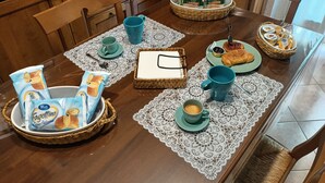 A dining table set with various food items and drinks, including bread, pastries, and coffee, in a kitchen setting. - Tra Pirandello e Leopardi B&B (Naples)