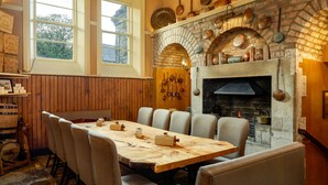 Un comedor con chimenea de ladrillo, mesa de madera y sillas.