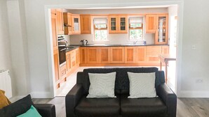 Una cocina moderna con armarios de madera y un sofá de cuero negro en la sala.