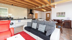 A modern living room with a red sofa, a black and white patterned sofa, and a red rug. - Zeruhaundi - baskeyrentals (Biscay)