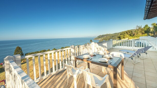 A terrace with a table set for two, overlooking a coastal view. - Zeruhaundi - baskeyrentals (Biscay)
