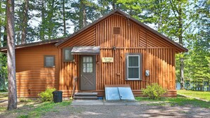 Une cabane rustique avec une façade en bois, une porte d’entrée, un petit porche et une pancarte sur laquelle on peut lire : « Cabane pour se ressourcer ».