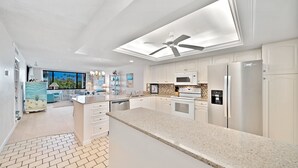 Una cucina moderna con mobili bianchi, un piano di lavoro in granito ed elettrodomestici in acciaio inossidabile.