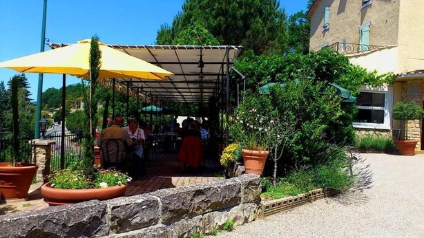 Un espace extérieur aménagé, abrité et doté de murs en pierre et de plantes en pot.