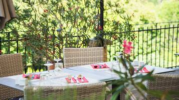 An outdoor dining area with wicker furniture and a table set for two.