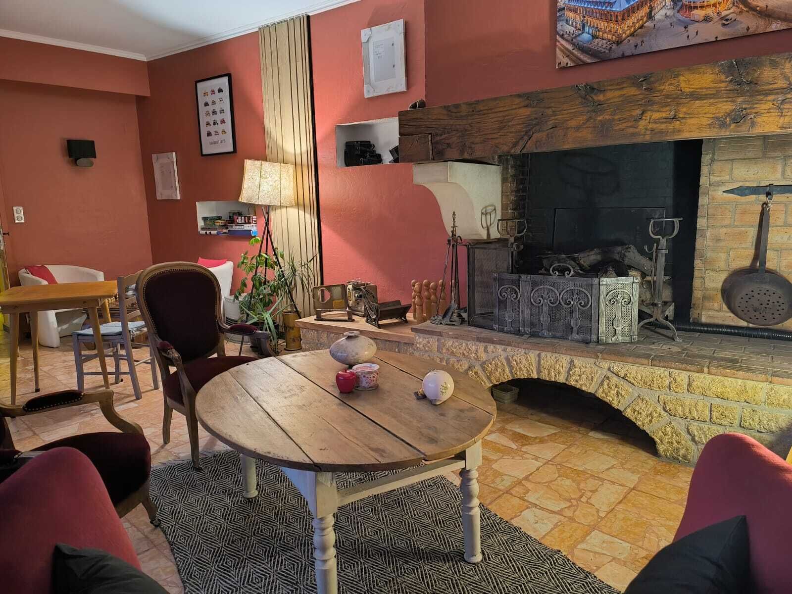 A cozy living room with a fireplace, a dining table, and comfortable seating.