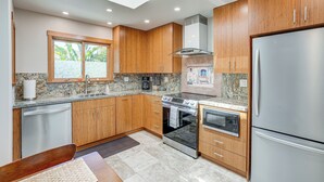 A modern kitchen with wooden cabinets, stainless steel appliances, and a skylight. - Alameda Studio w/ Patio: 3 Mi to Oakland Coliseum! (Alameda)