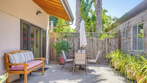 A patio with a wooden bench, a table with chairs, and potted plants. - Alameda Studio w/ Patio: 3 Mi to Oakland Coliseum! (Alameda)