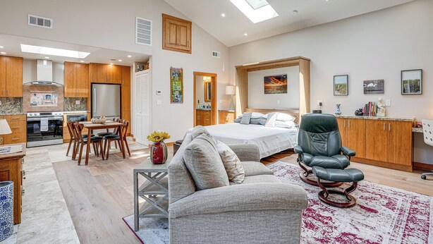 A spacious living area with a sofa, a dining table, and a kitchen in the background. - Alameda Studio w/ Patio: 3 Mi to Oakland Coliseum! (Alameda)