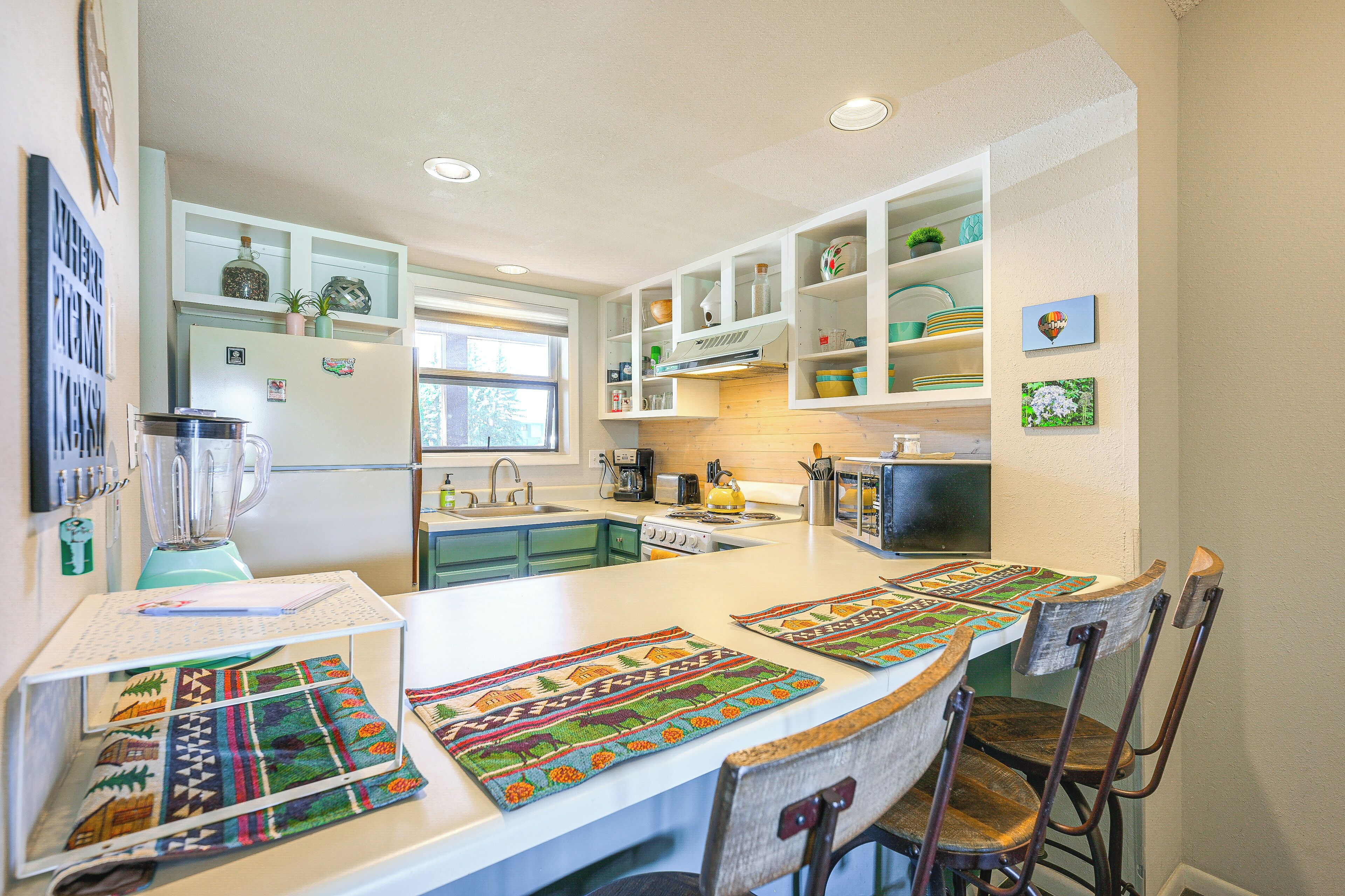 A modern kitchen with a central island, built-in shelves, and a variety of appliances.
