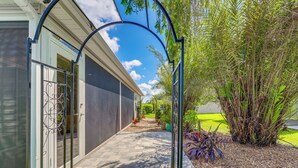 A pathway leading to a house with a covered porch and a garden with various plants. - Golf Cart & Pool Access: The Villages Home! (Wildwood)