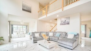 A spacious living room with a grey sectional sofa, a white coffee table, and a marble floor. - Hike, Sip & Ski: Spacious Poconos Home (Kunkletown)