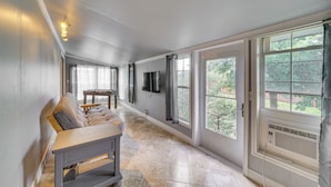 A spacious room with a large window, a flat-screen TV mounted on the wall, and a wooden bench. - On-site River Access: Medina Vacation Rental (Medina)