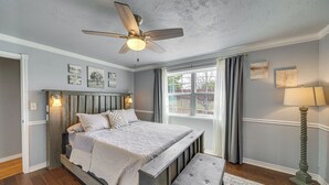 A bedroom with a wooden bed, a bench, a ceiling fan, and a window with curtains. - On-site River Access: Medina Vacation Rental (Medina)