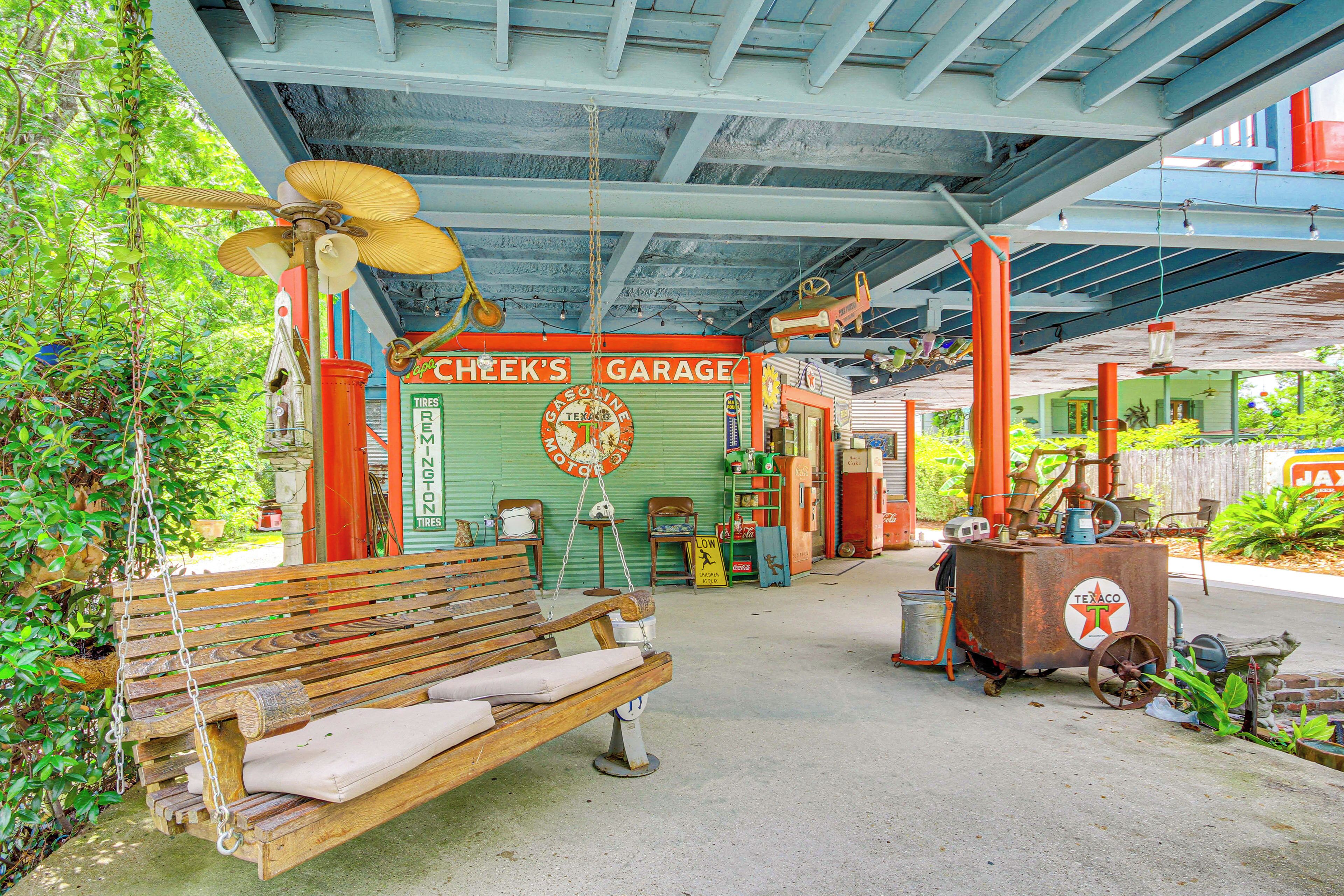 A vintage garage with a wooden bench, a hanging fan, and various tools and equipment.