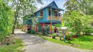 A rustic, two-story building with a porch and a sign that reads "Cheek's." - Eclectic Mandeville Home: Walk to Lakefront Park (Mandeville)