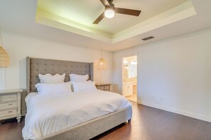 Ein Schlafzimmer mit einem großen Bett, einem Deckenventilator und einem Nachttisch.
