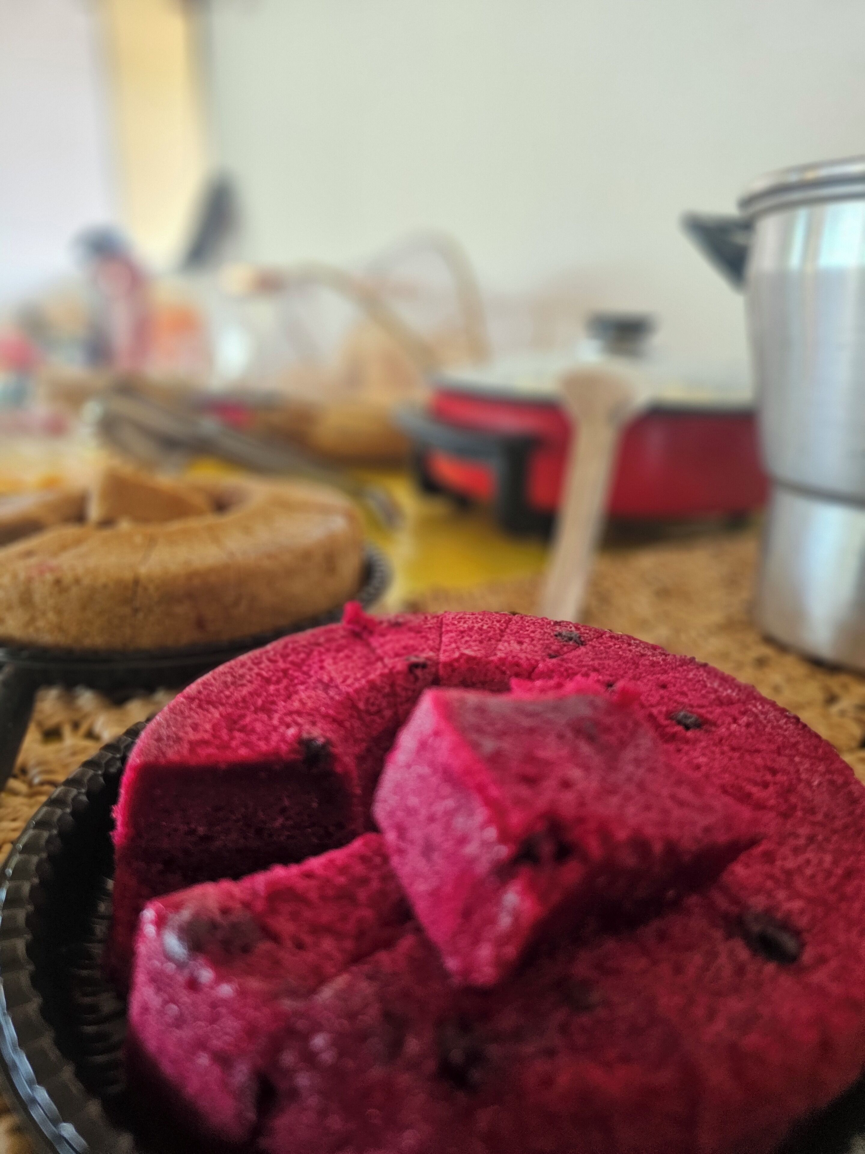 A close-up of a red cake with a textured surface, placed on a plate.