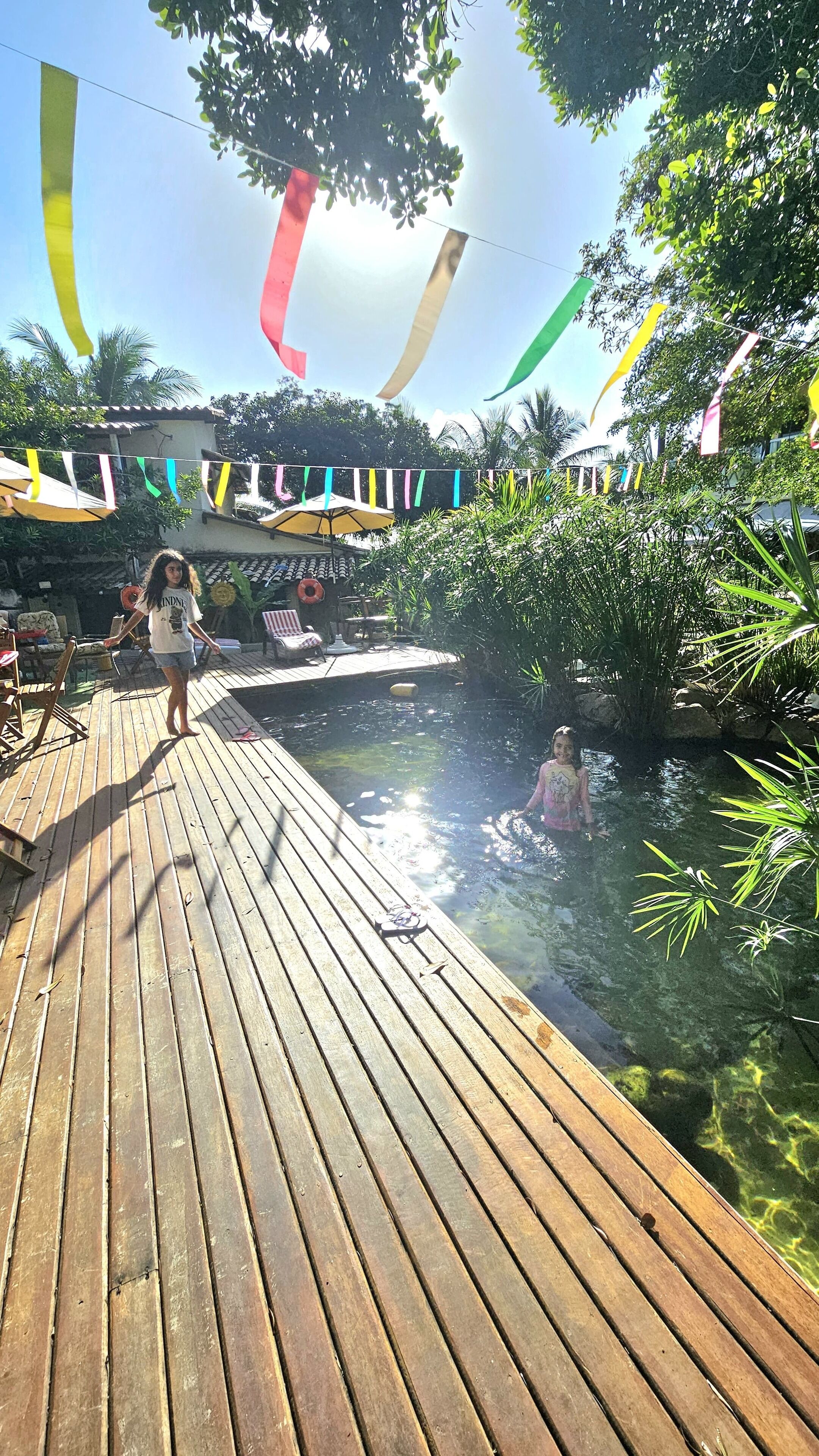 Una piscina al aire libre, sombrillas, sillones reclinables de piscina