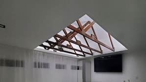 Ein modernes Schlafzimmer mit Oberlichter, einem Bett, einer Couch, einem Fernseher und einer Essecke.