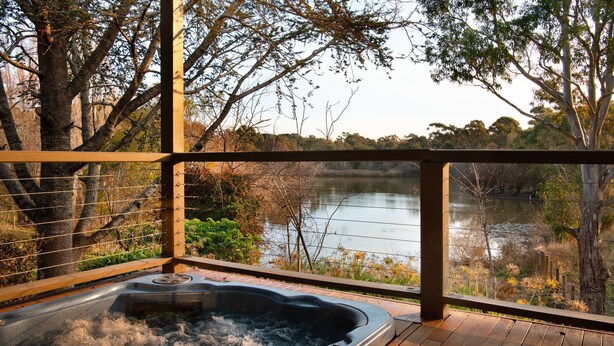 A hot tub with a view of a lake and surrounding trees. - The Falls at Lake Werona (Werona)