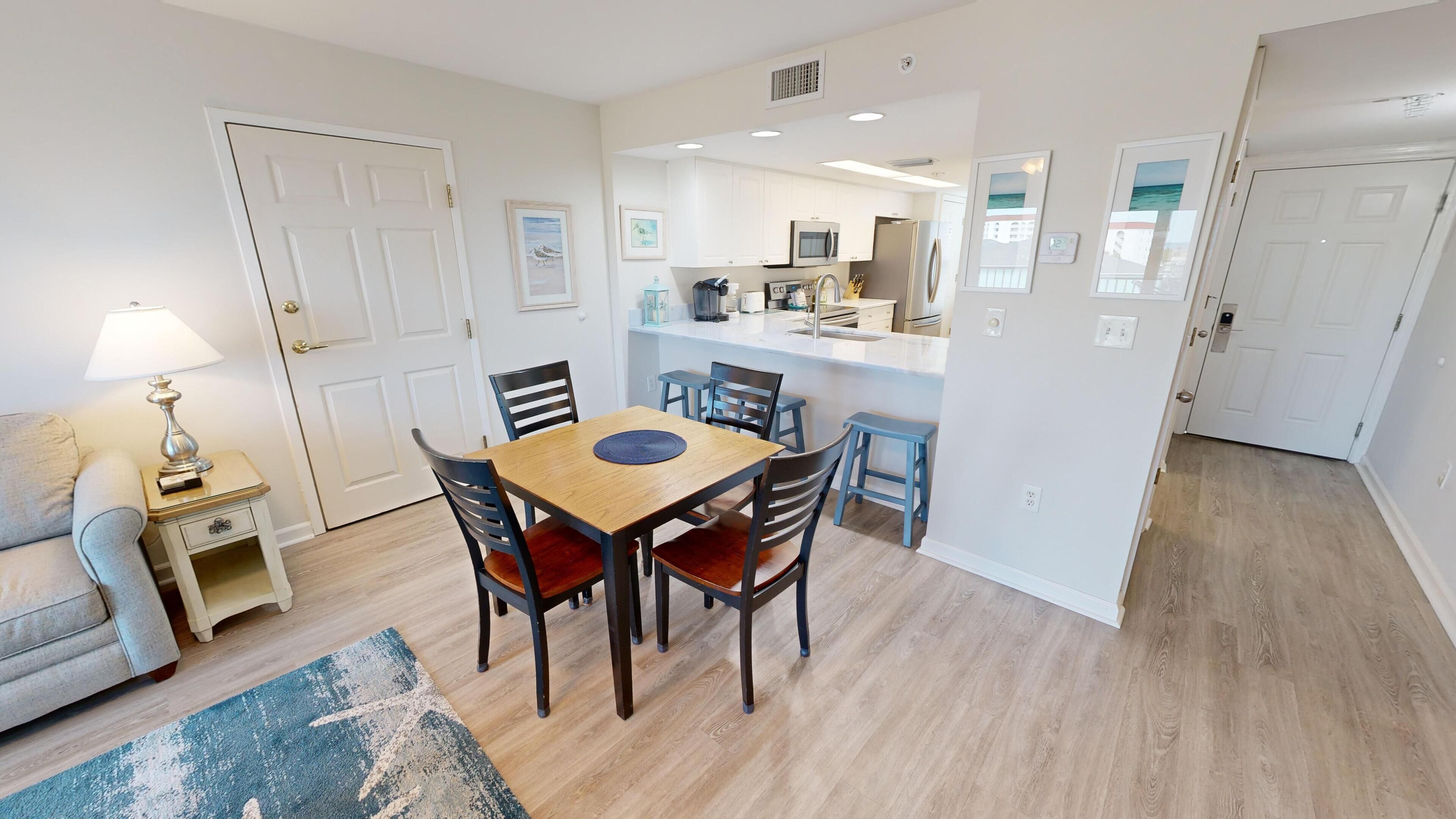A compact living space with a dining area, kitchenette, and a small seating area.