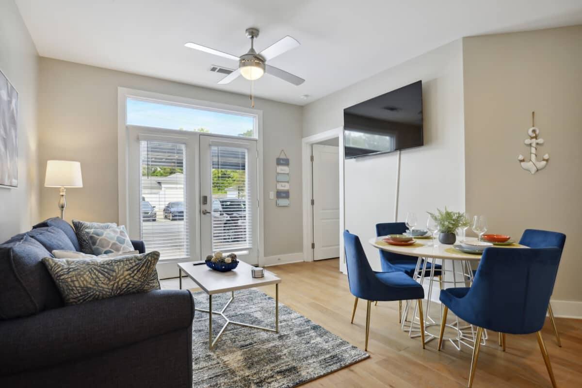 A modern living room with a sofa, coffee table, and dining area with chairs.