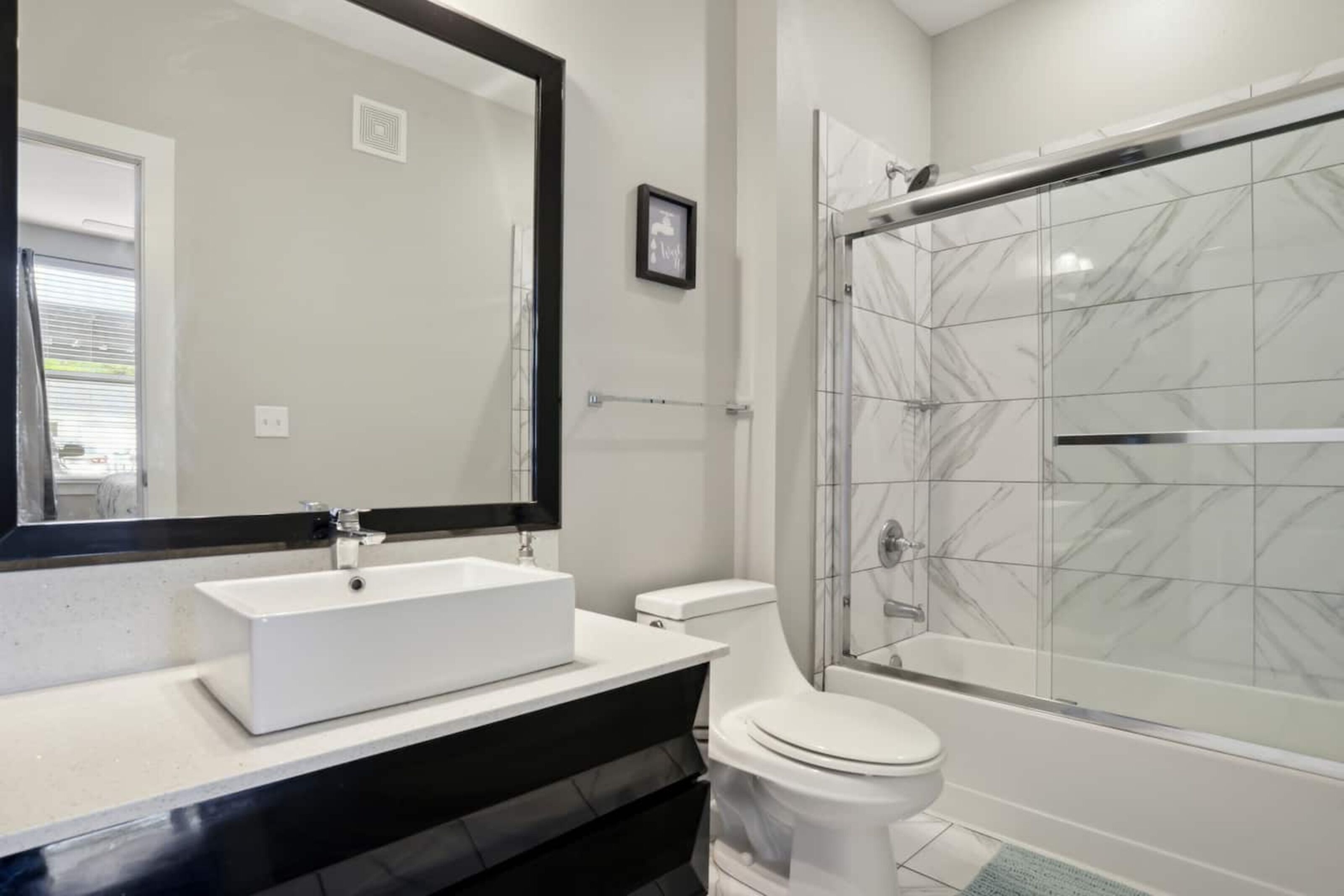 Un bagno con un lavandino bianco, un water e una cabina doccia in vetro.