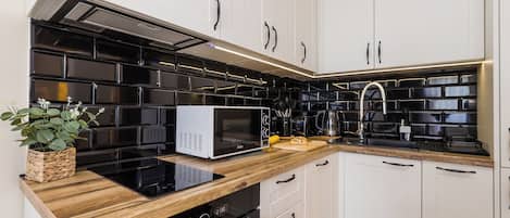 Een koelkast/vriezer, een magnetron, een oven, een kookplaat